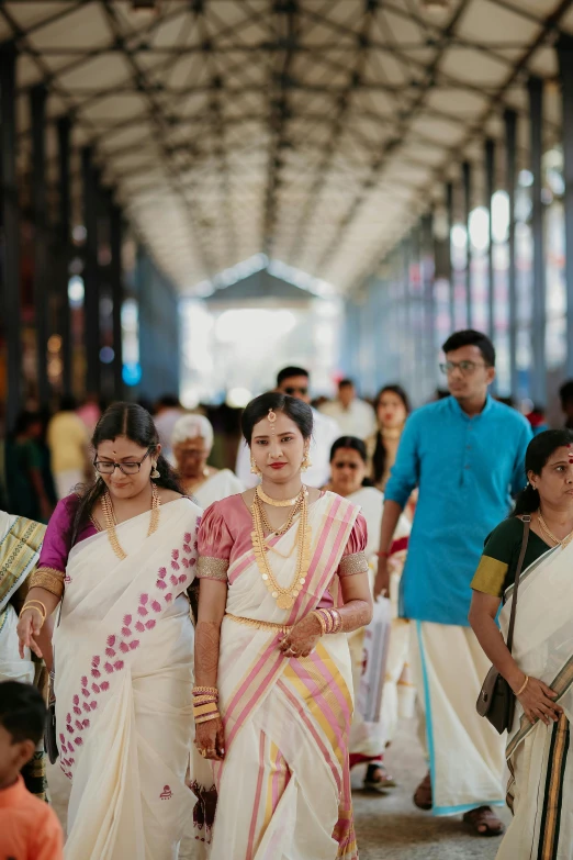 three women walk in the aisle of a train station