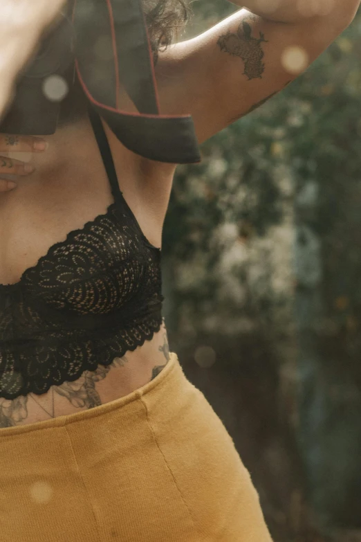 the young woman with tattoos is wearing a black 