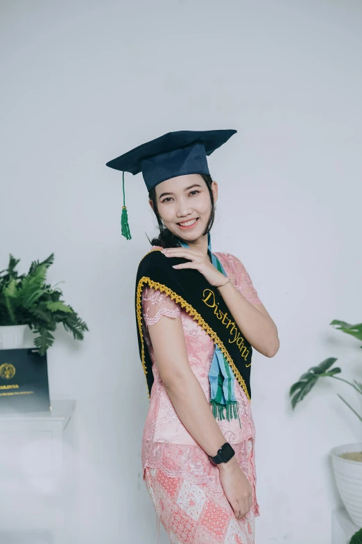 the young woman in the graduation gown poses for a picture