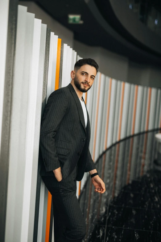 a man in a suit is leaning against the wall