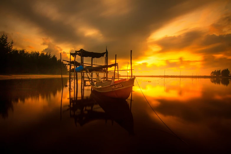 a small boat sitting in the water with its reflection