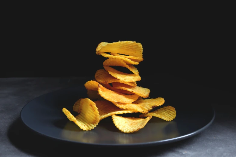 there are crispy chips stacked up on a plate