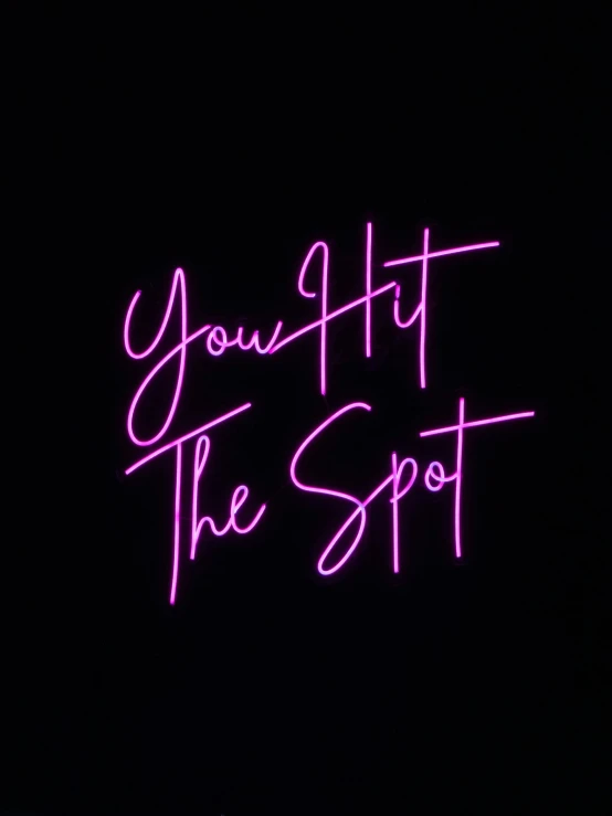 a neon pink message that says you're the spot on a dark background