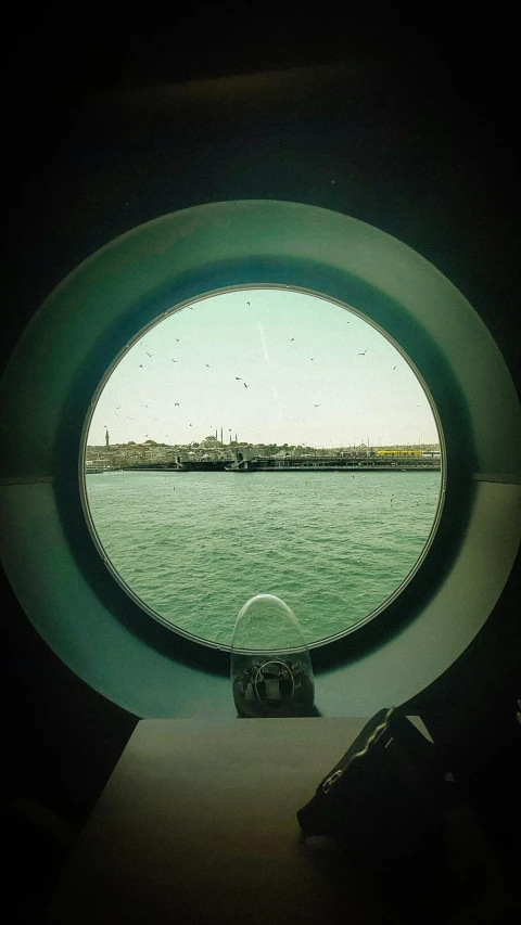 an round port window overlooking water near land