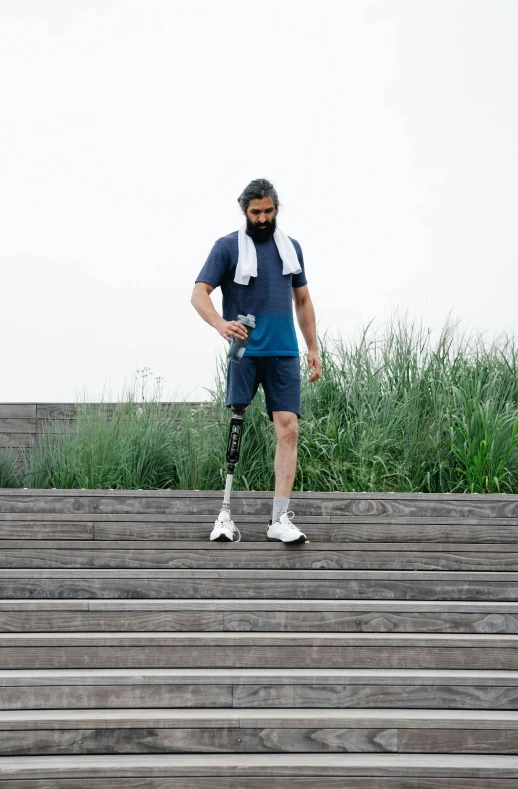 man in blue and white baseball uniform with knee ce standing on a staircase