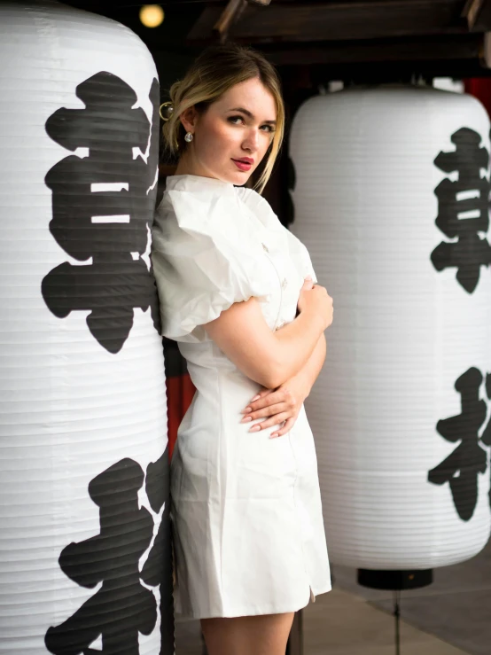 a woman standing next to two chinese lanterns