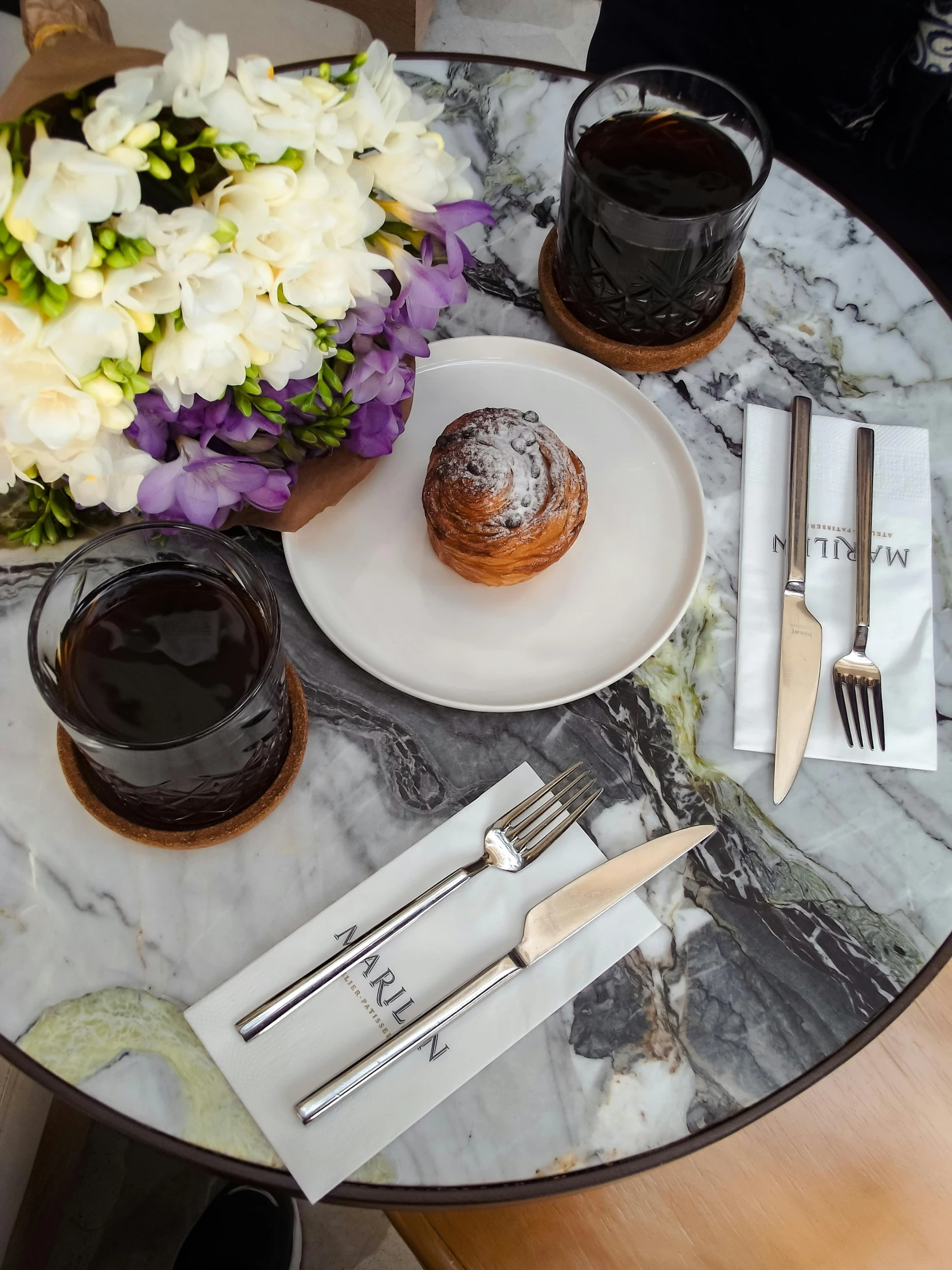 a round table has an ice - cream and pastries and silverware on it