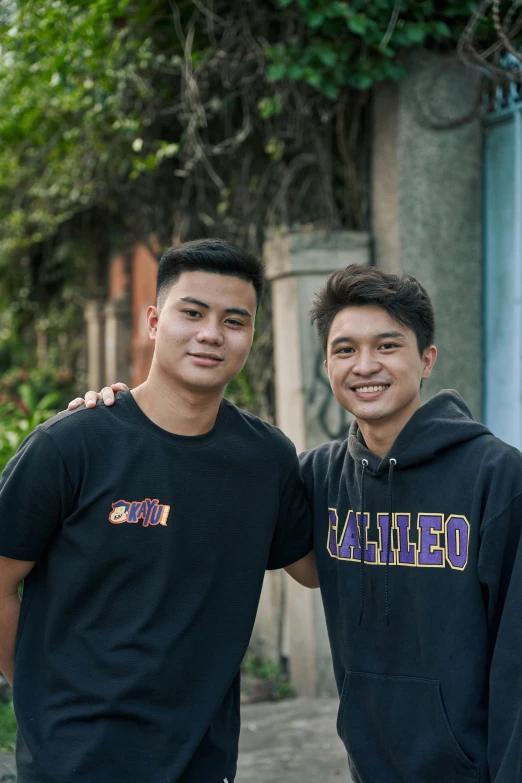 two young men posing for the camera on a sunny day