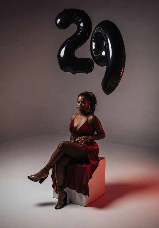 a woman sitting in a chair and balloons in the air