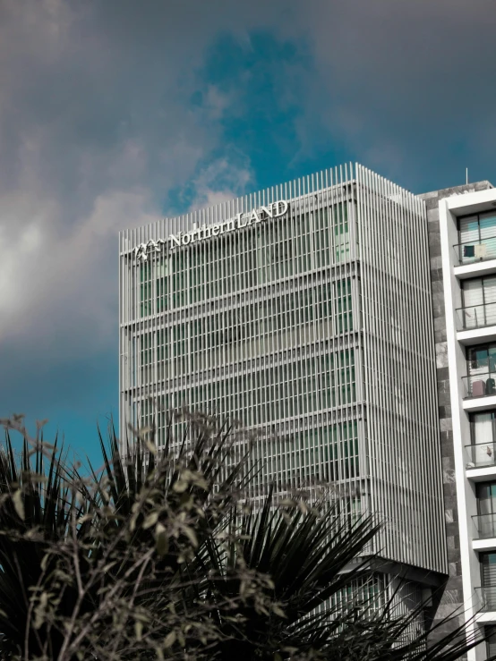 a very tall building sitting in front of a blue cloudy sky