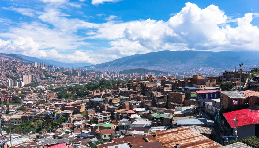 a city with many roofs and mountains in the distance