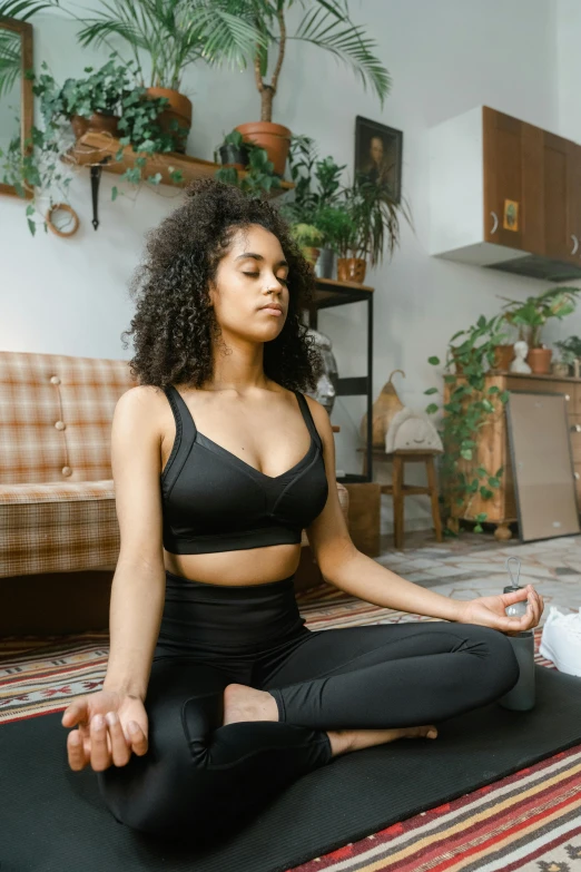 woman in yoga outfit sitting on a mat