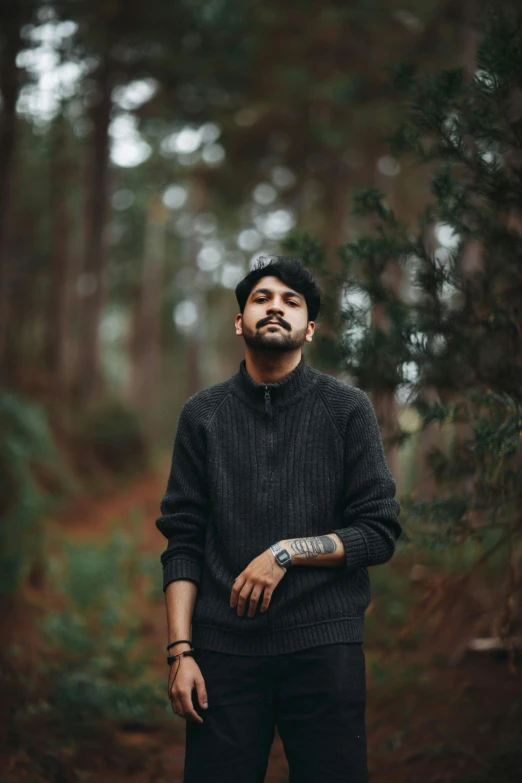 a man is standing in a forest and looking upward