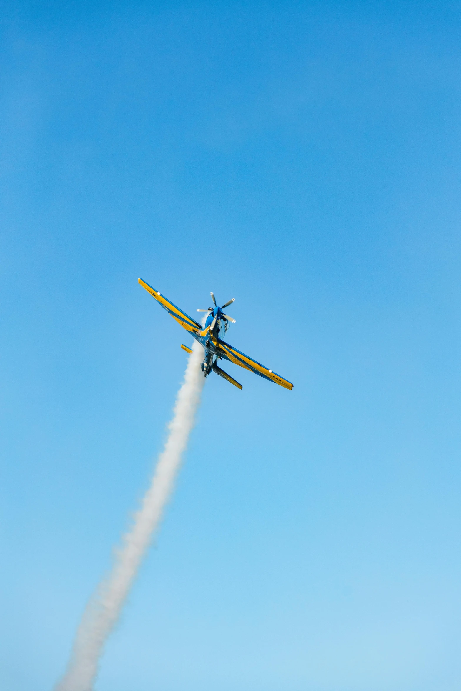 a small airplane flying through the blue sky