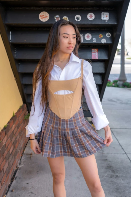 a beautiful young woman standing on the sidewalk