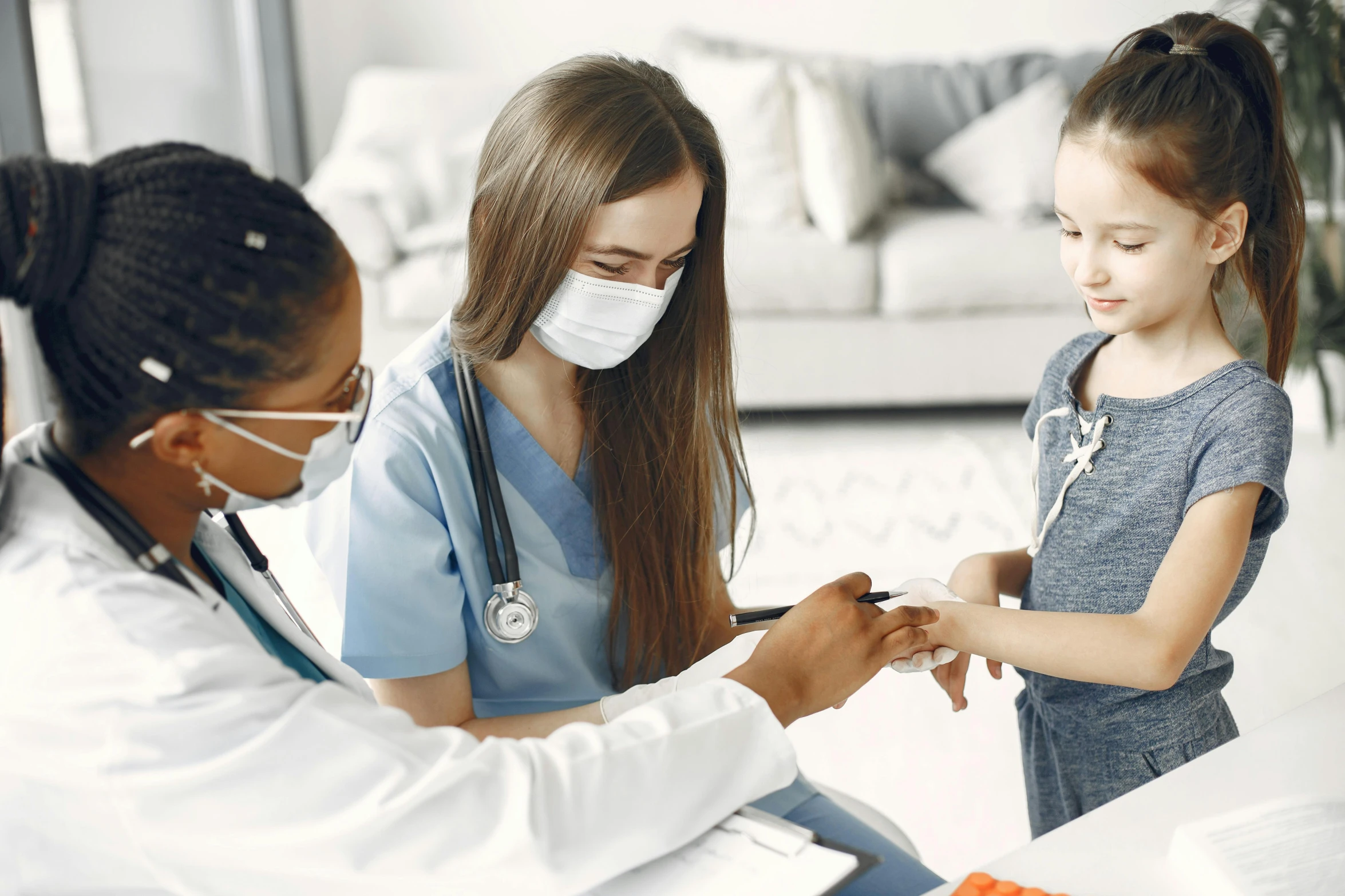 a woman with her daughter who is wearing a face mask and check her vaccium