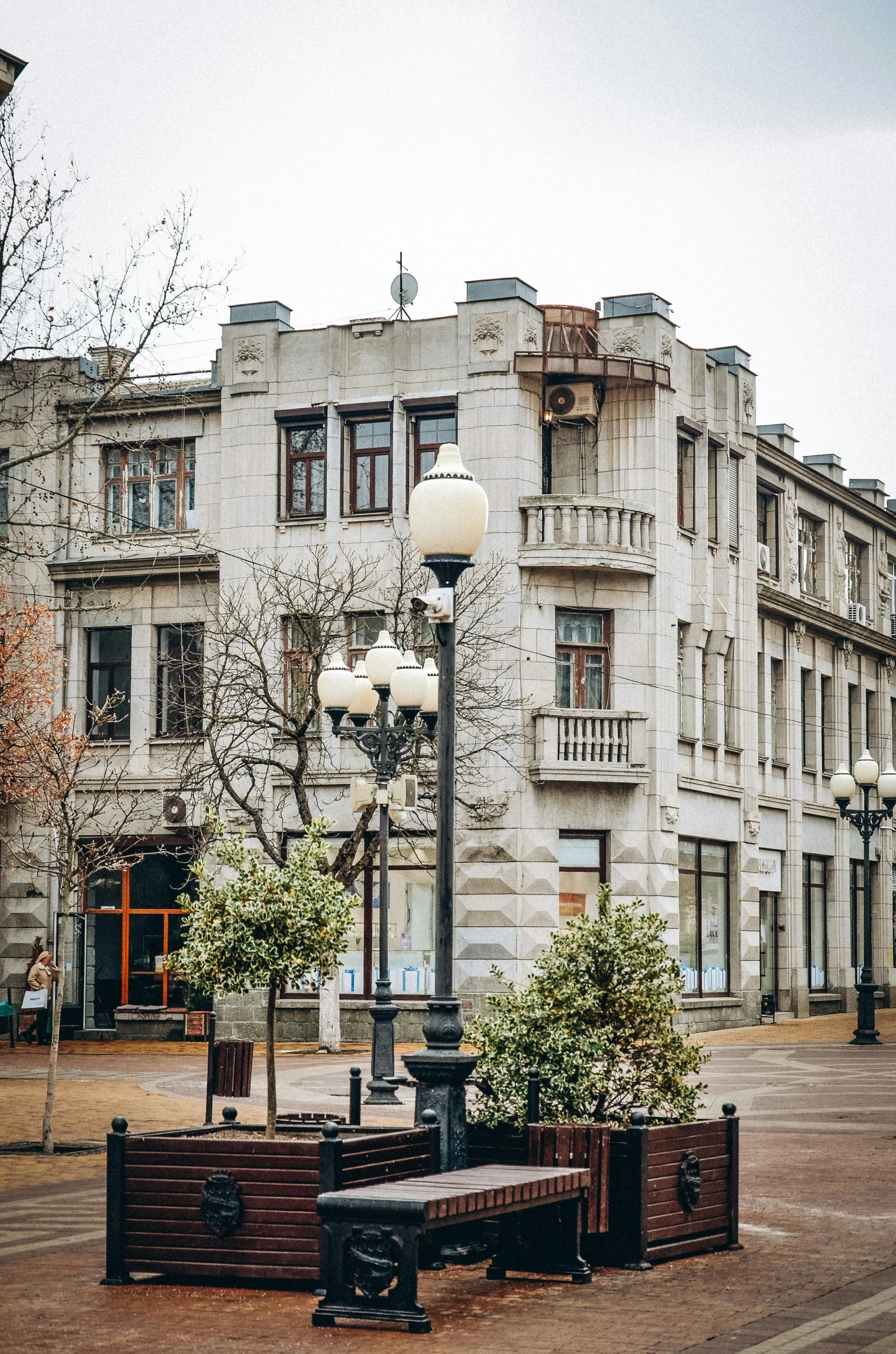 the building with a lamppost is empty, next to a park bench