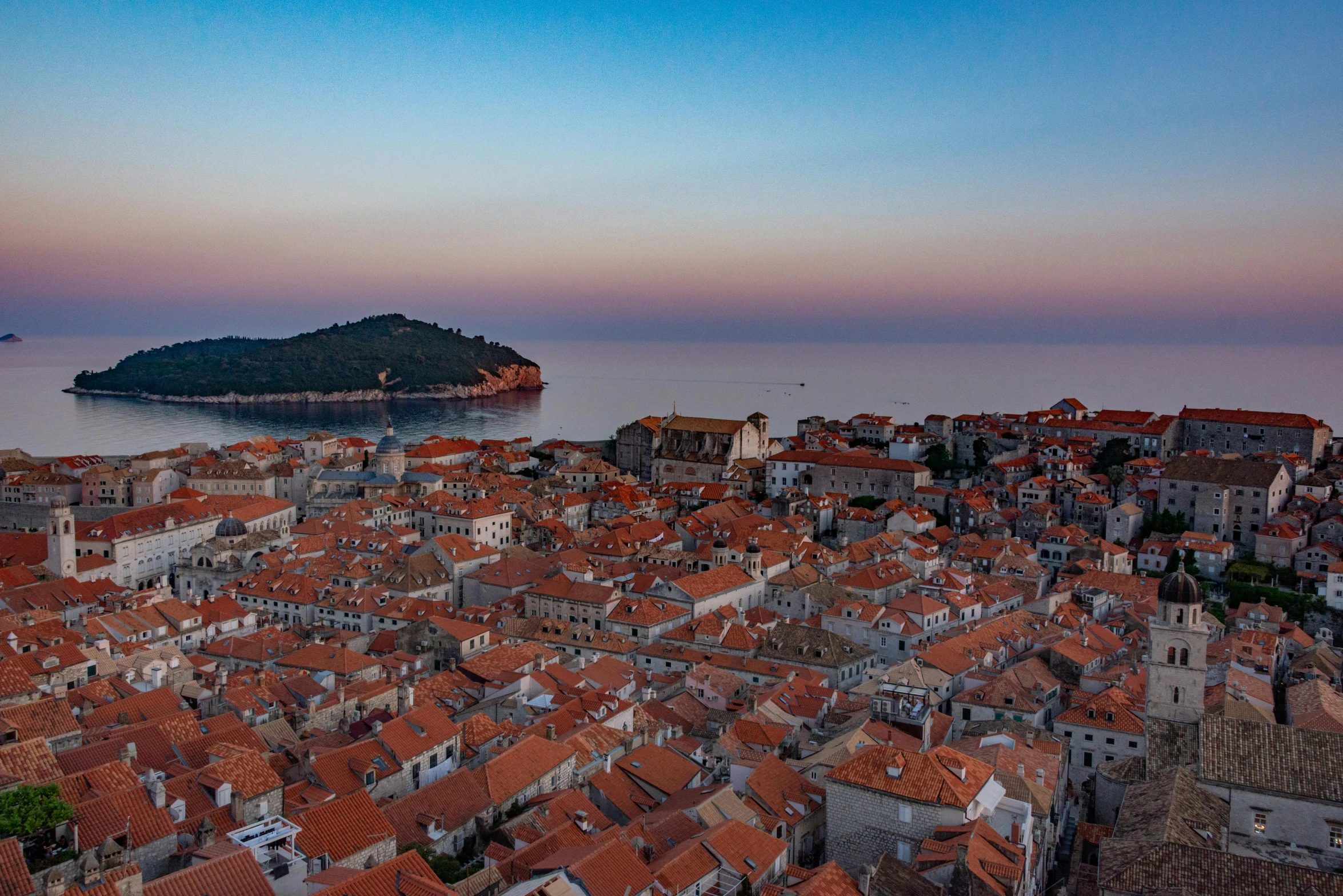 a view of an area that has rooftops, and the ocean