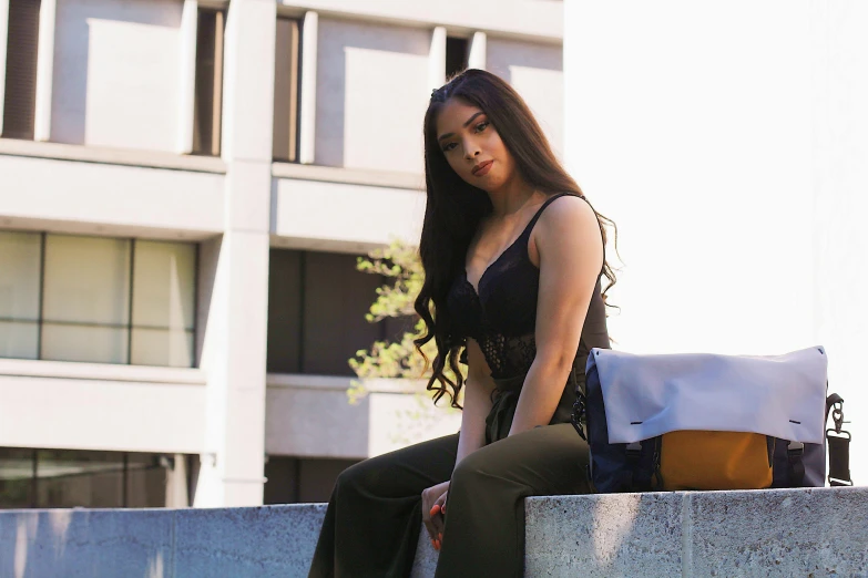 a woman sitting down with a bag next to her