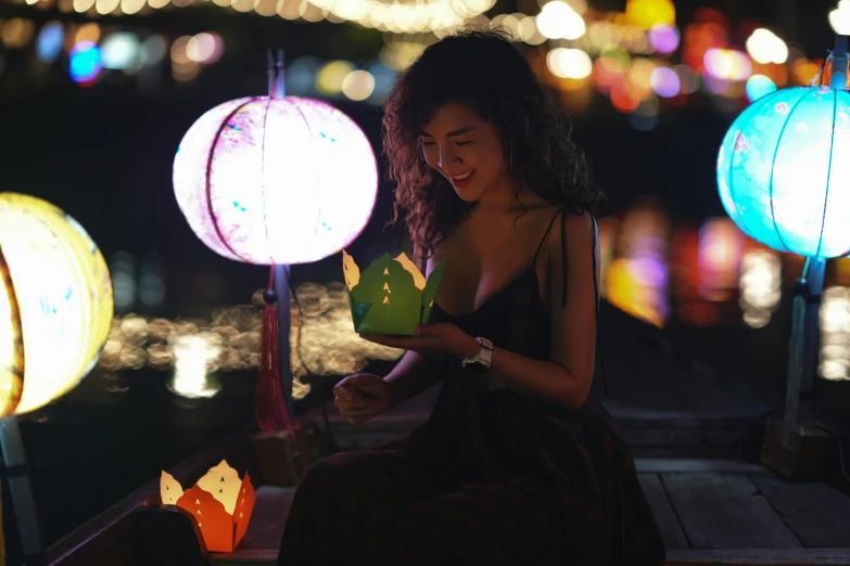 a young woman smiles at a paper lantern