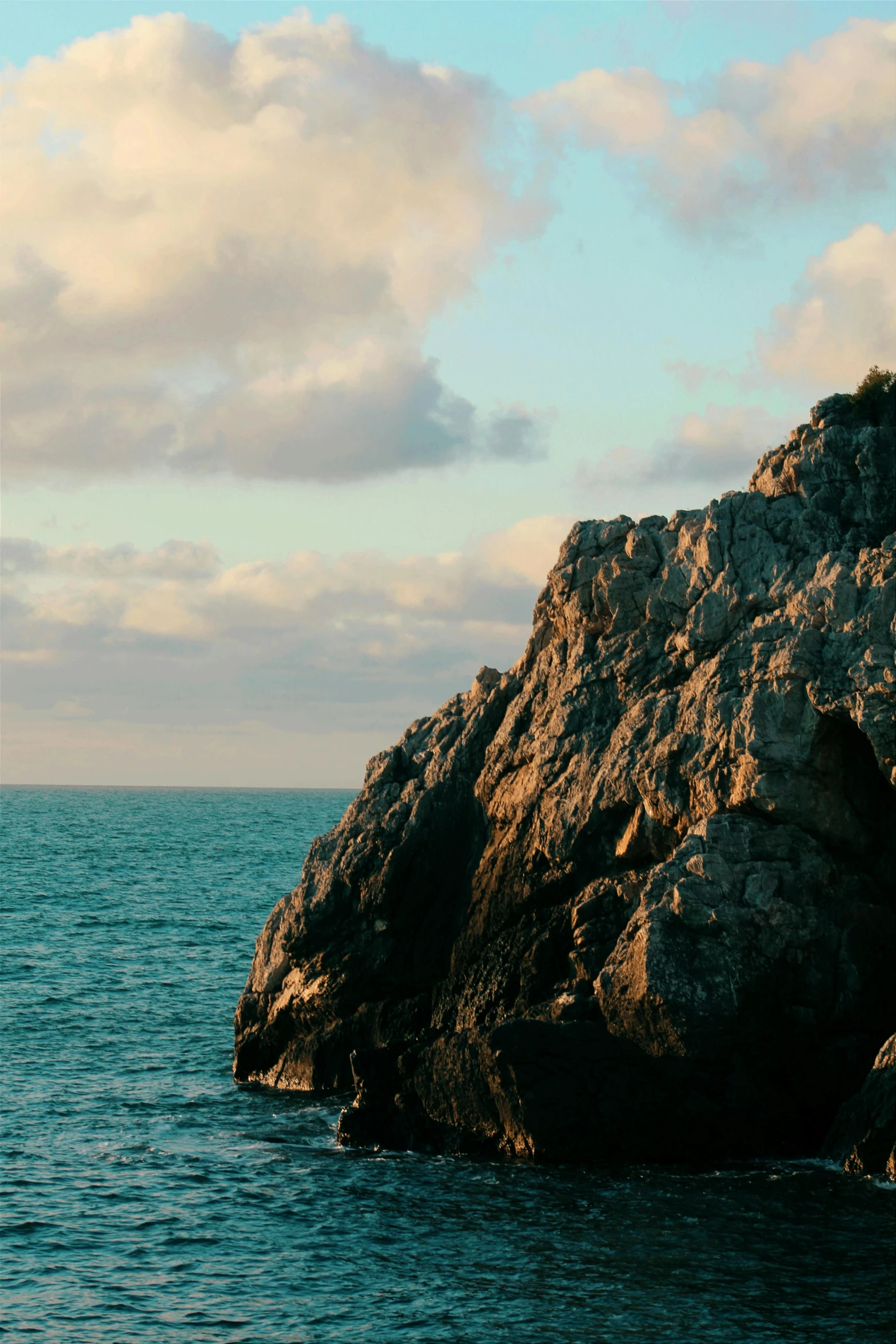 an ocean with a large rock out in the middle of it