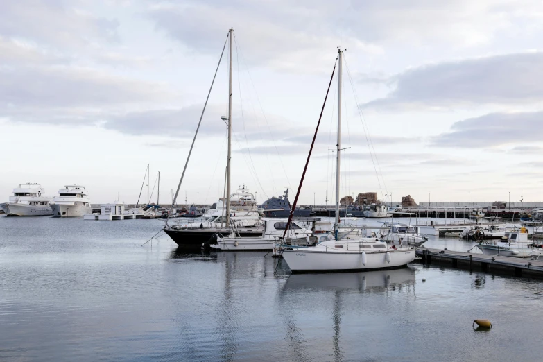 boats are docked at a harbor in the evening