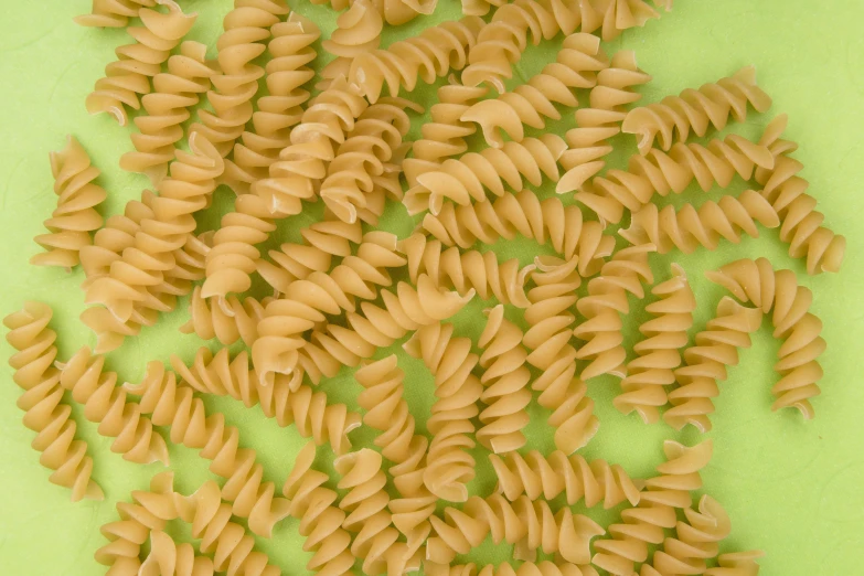 a pile of macaroni shells, on a green background