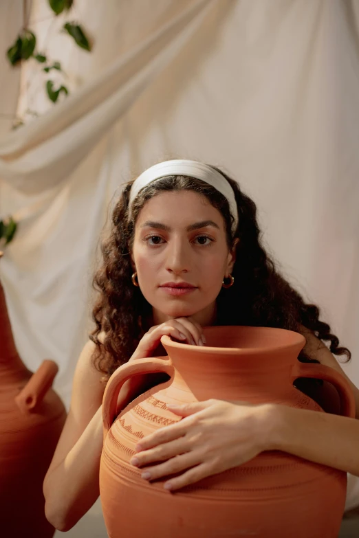 a woman is putting her hand on an orange pot