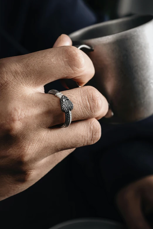 a close up of a person's hand holding a cup