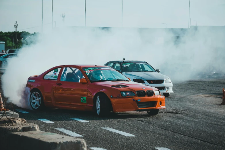 smoke billows from two parked cars with other cars in the background