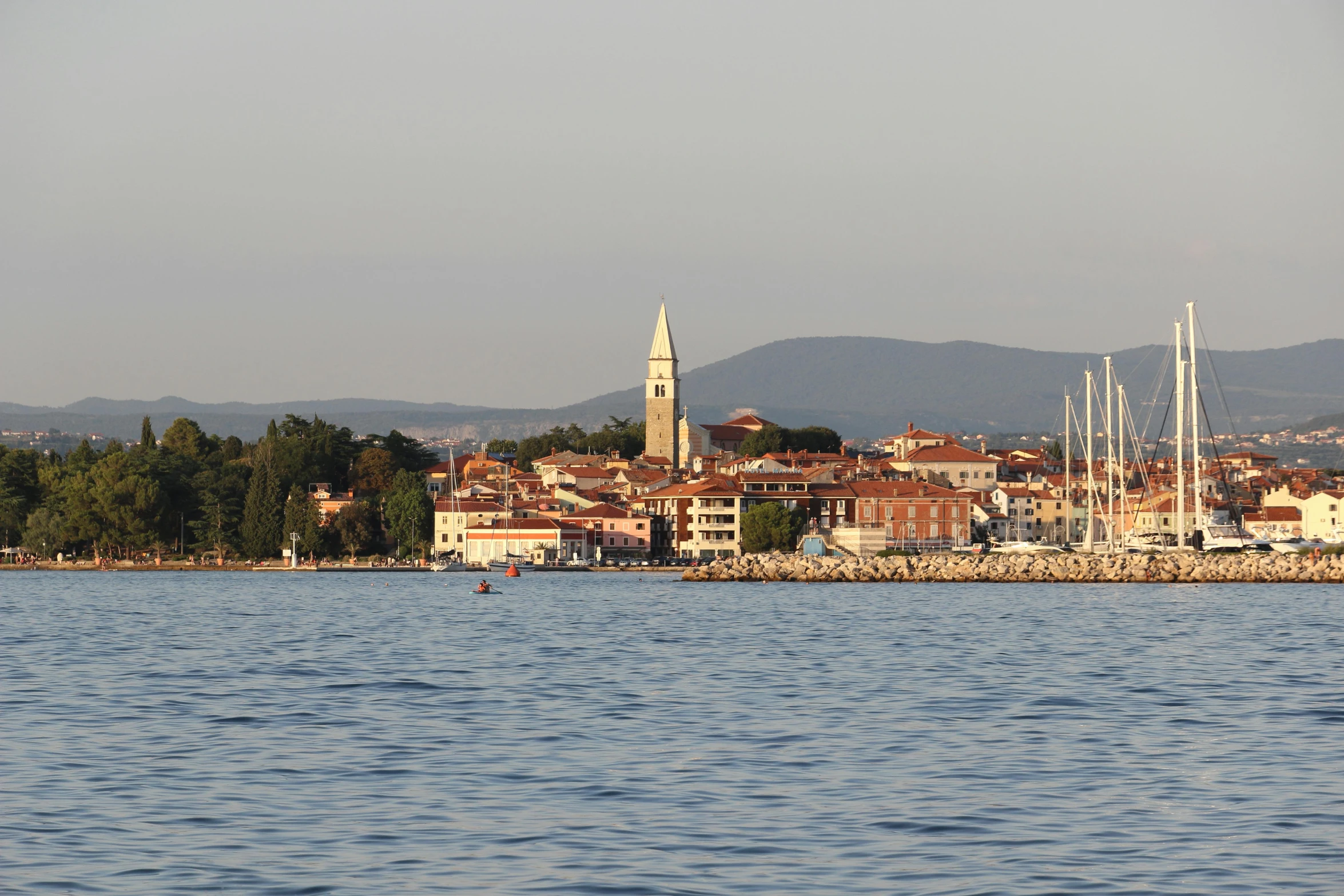 a sailboat sailing through the water in front of an island