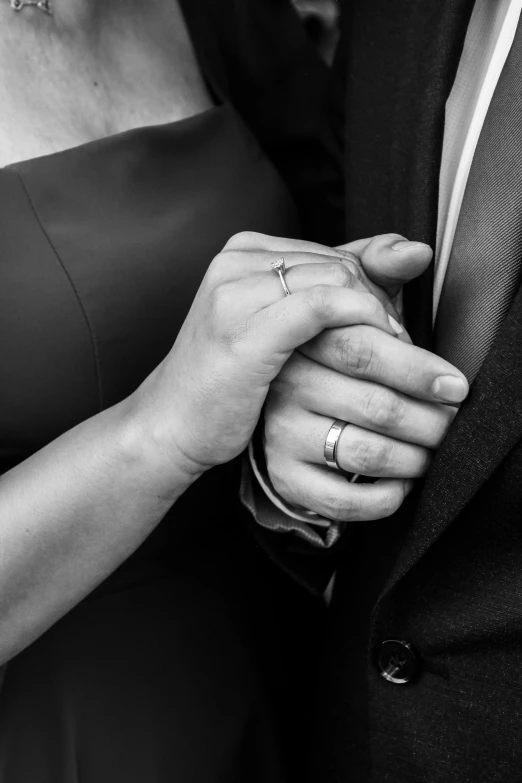 two people are holding hands in black and white