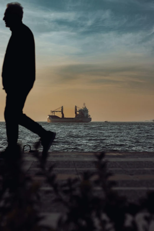 a silhouette of a man in front of the ocean