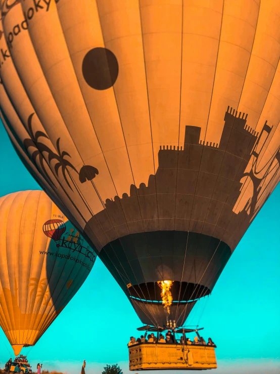 an orange balloon in the sky, with other balloons behind