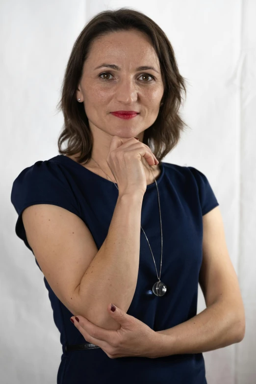 a woman with a necklace is smiling