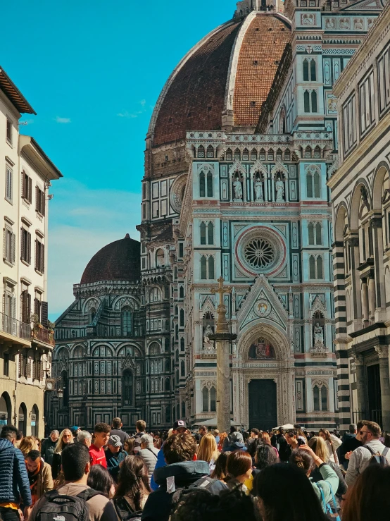 a crowd of people gather in front of a large building