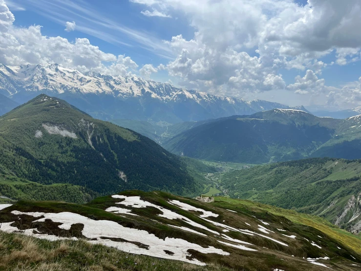 mountains in the distance and a grassy slope with a bench