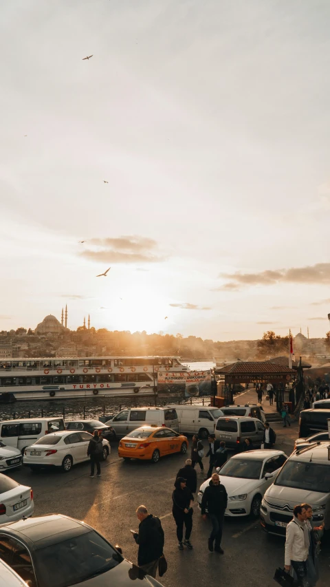 a crowd of people walk across the parking lot