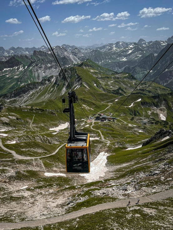 a gondola car going through the mountain with a view of the valley below