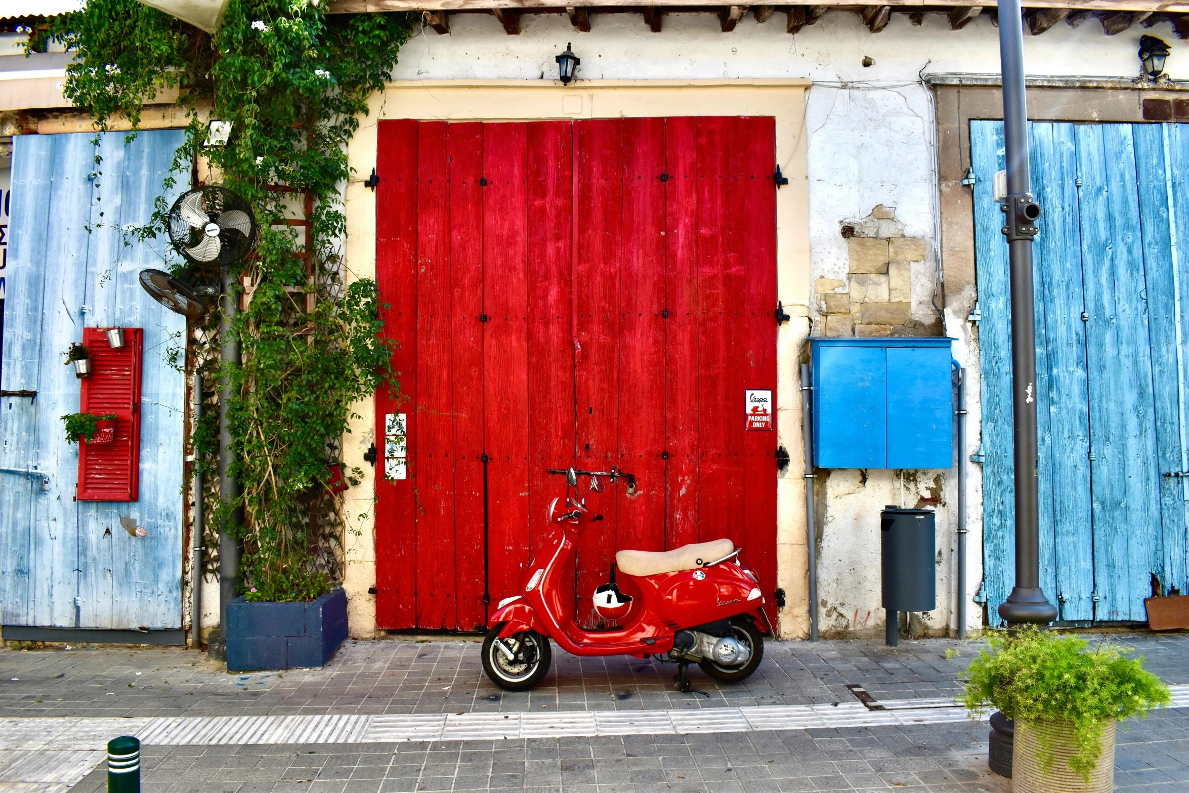 a red motorcycle parked in front of a wooden door