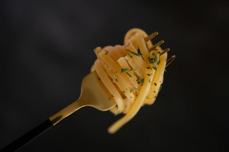 there is some pasta on a fork and a black background