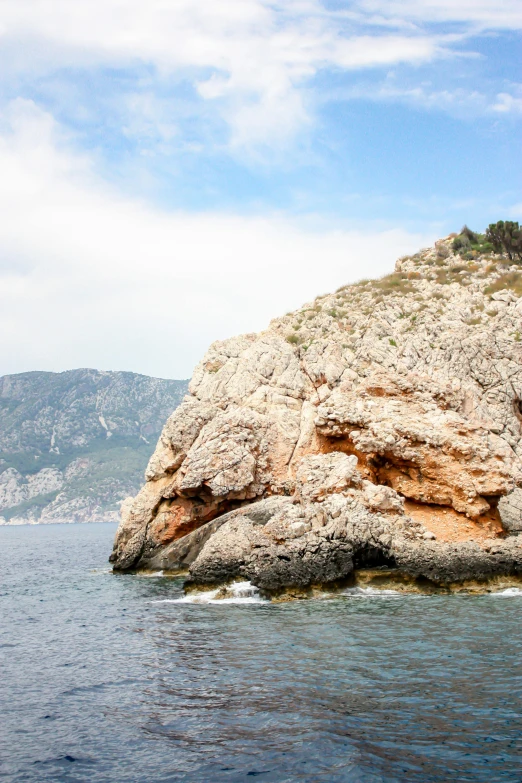 large rock formations sitting out on the side of a body of water