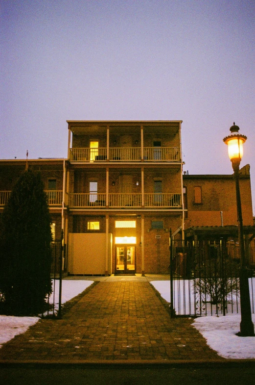 the streetlight shines bright in front of a large home