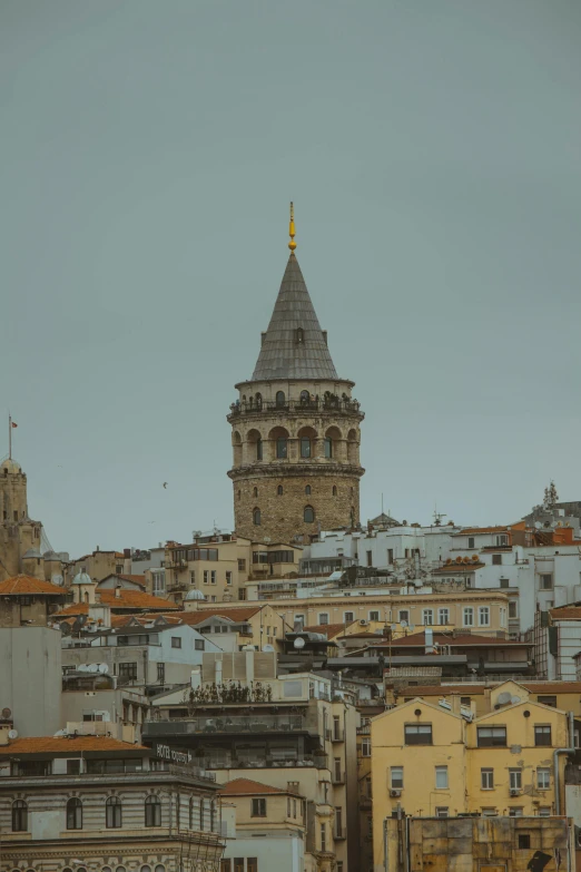 an old tower and some buildings on the hill