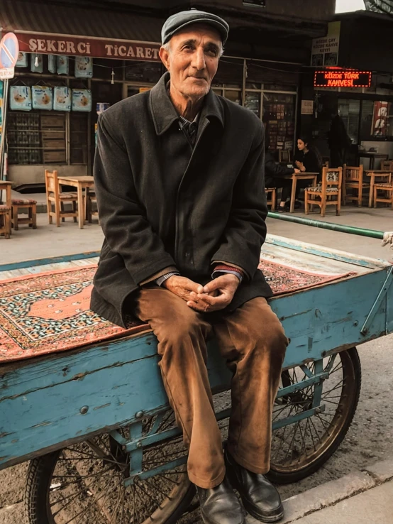 a person sitting on a bike with an oriental tile covered side table