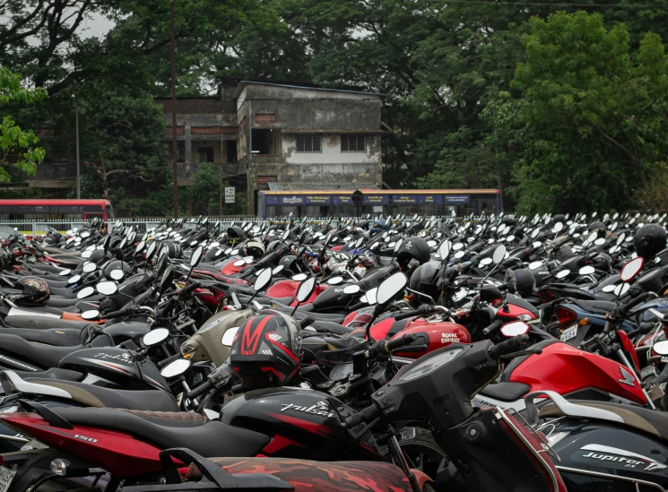 a lot of mopeds parked next to each other in a field
