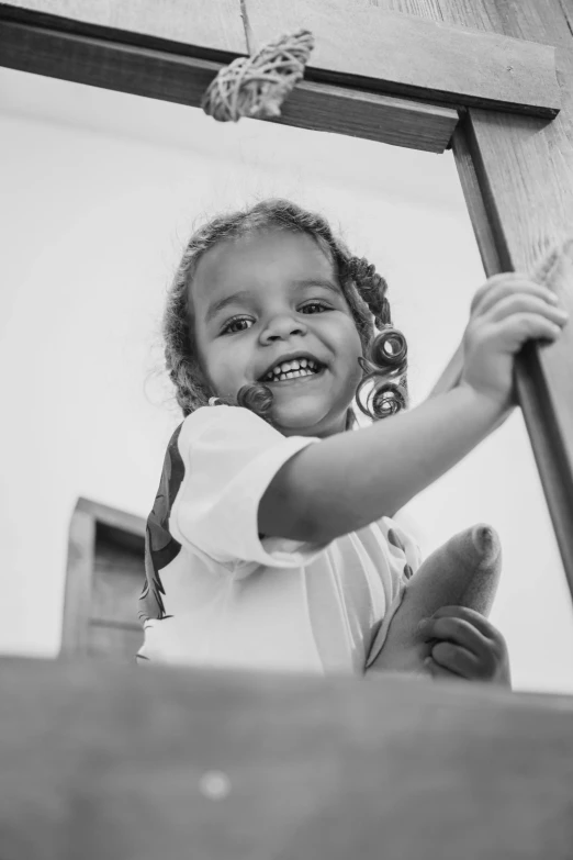 a little girl standing in front of a cross