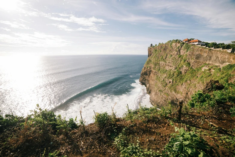 the ocean sits at the bottom of the cliff