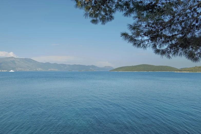 an ocean, with mountains in the background and a body of water