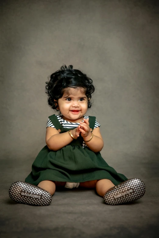 an adorable baby sitting down posing for a po